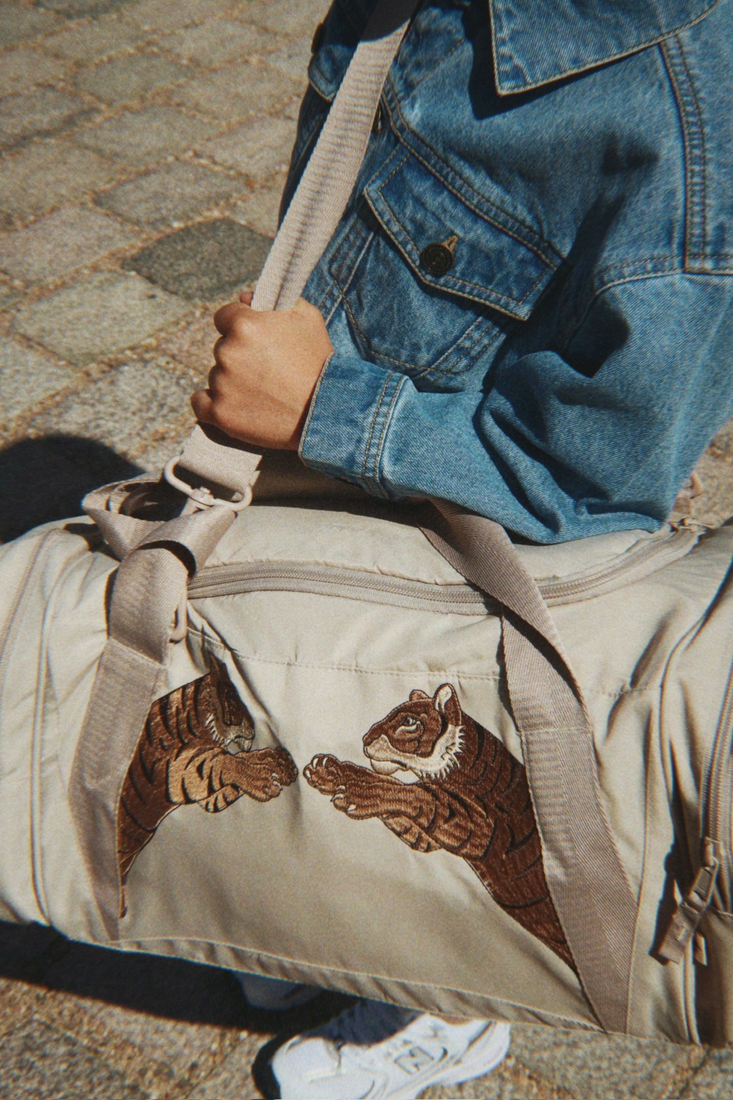 Kind mit stylischer Sporttasche über der Schulter, minimalistische Kinder Reisetasche Konges Slojd