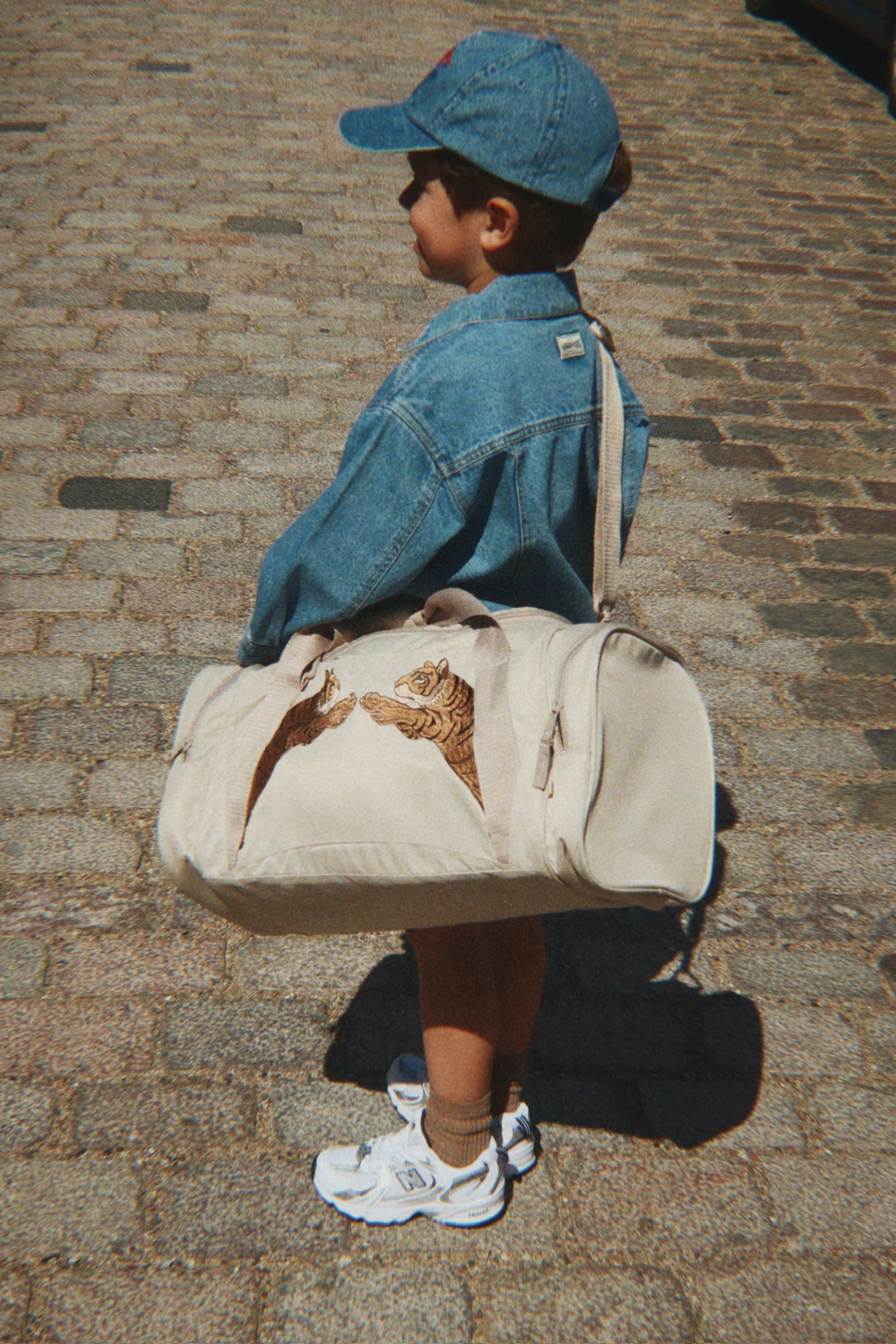 Kind mit Sporttasche über der Schulter, minimalistische Kinder Reisetasche